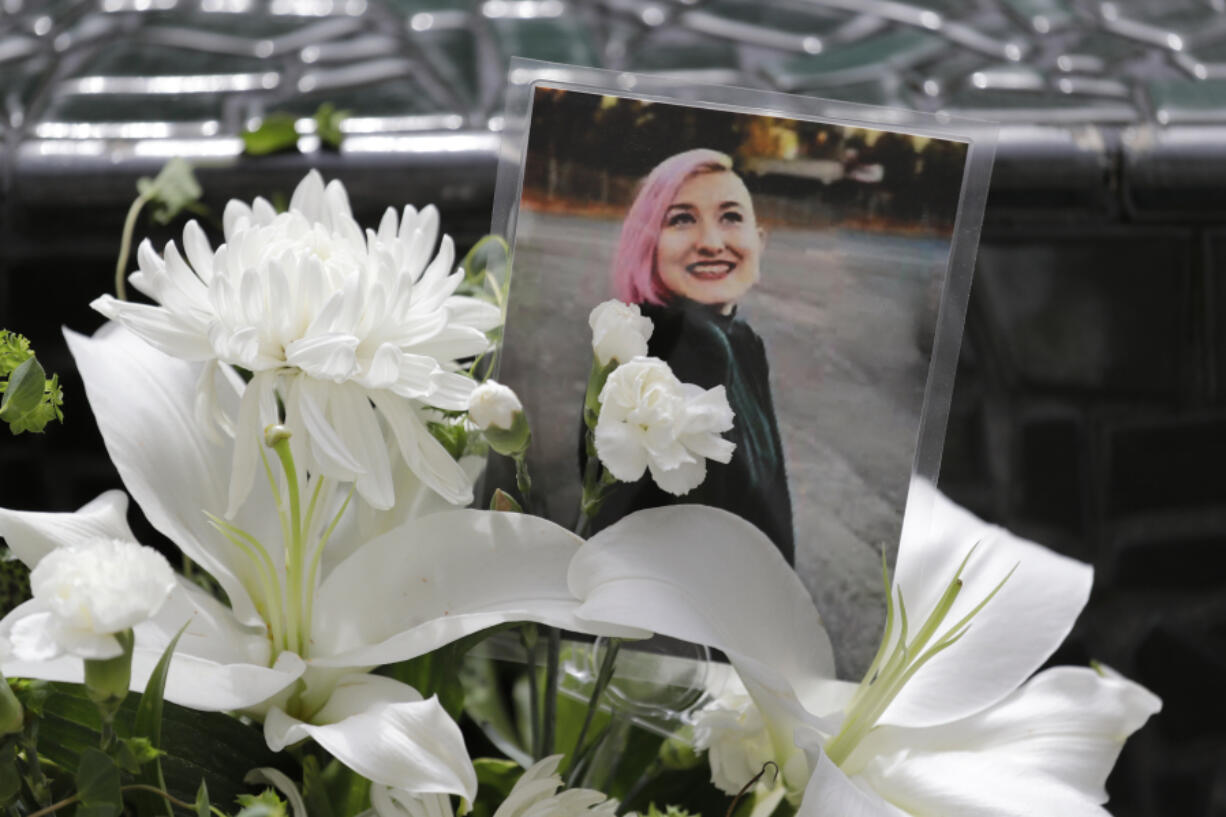 FILE - A photo of Summer Taylor, who suffered critical injuries and died after being hit by a car while protesting over the weekend, sits among flowers at the King County Correctional Facility where a hearing was held for the suspect in their death on July 6, 2020, in Seattle.