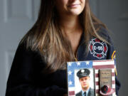 Capri Yarosz holds a photo of New York firefighter Christopher Michael Mozzillo, Saturday, Sept. 7, 2024, in Freehold, N.J.. Mozzillo, who died in the 9/11 attacks, was Yarosz&#039;s uncle. (AP Photo/Noah K.