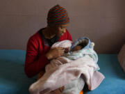 Mapule Radebe holds her baby Minehle at Nkosi&rsquo;s Haven, a home that assists women with HIV, on Aug. 5 in Johannesburg, South Africa.