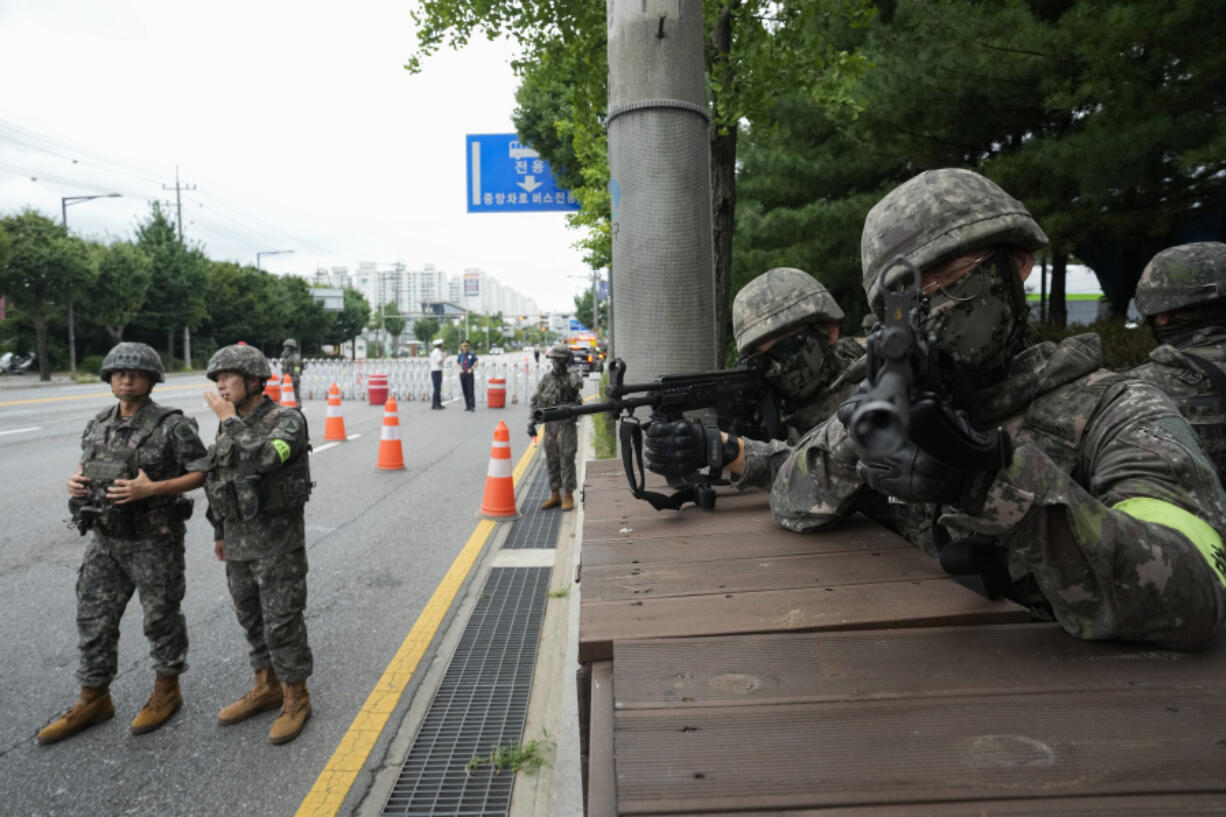 South Korean army soldiers aim their machine guns as they control traffic during a civil defense drill as a part of the Ulchi Freedom Shield military exercise between the U.S. and South Korea in Seoul, South Korea, Thursday, Aug. 22, 2024.