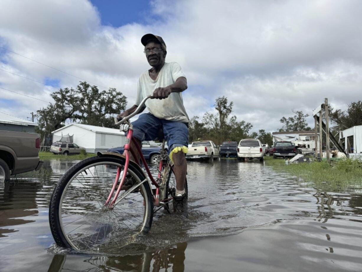 Carter Caldwell bikes through his family&#039;s flooded property just south of Houma, La., after Hurricane Francine tore through the area, Thursday, Sept. 12, 2024.