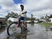 Carter Caldwell bikes through his family&#039;s flooded property just south of Houma, La., after Hurricane Francine tore through the area, Thursday, Sept. 12, 2024.