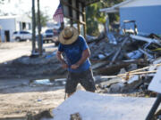 Chris Jordan, maintenance manager for Horseshoe Beach, tries to find a water shutoff valve amid the rubble of the destroyed city hall in the aftermath of Hurricane Helene, in Horseshoe Beach, Fla., Sunday, Sept. 29, 2024.