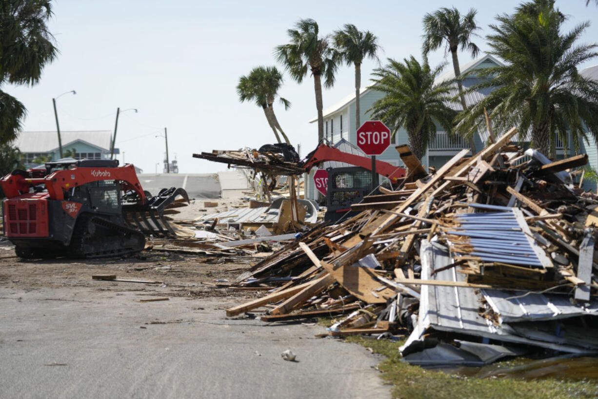 Workers remove debris in the aftermath of Hurricane Helene, in Cedar Key, Fla., Friday, Sept. 27, 2024.