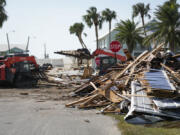 Workers remove debris in the aftermath of Hurricane Helene, in Cedar Key, Fla., Friday, Sept. 27, 2024.