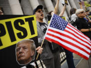 People protest against former President Donald Trump before his arrival to the New York Federal Court, Friday, Sept. 6, 2024, in New York.