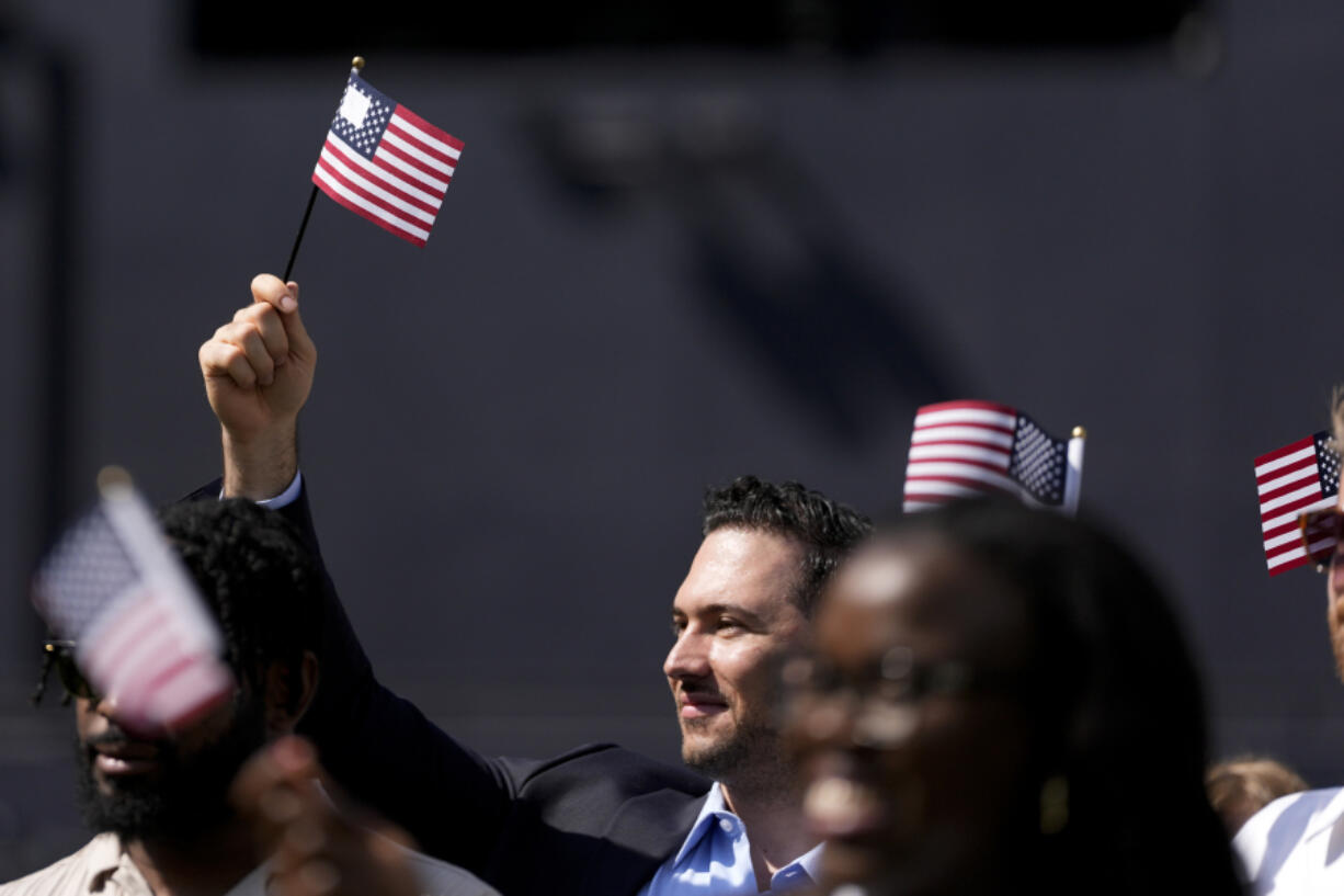 A man, part of a group of 50 new United States citizens from 25 different countries, takes part in a naturalization ceremony before the San Diego Padres host the Minnesota Twins in a baseball game at Petco Park, Wednesday, Aug. 21, 2024, in San Diego.