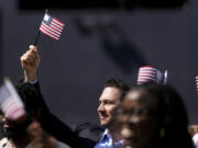 A man, part of a group of 50 new United States citizens from 25 different countries, takes part in a naturalization ceremony before the San Diego Padres host the Minnesota Twins in a baseball game at Petco Park, Wednesday, Aug. 21, 2024, in San Diego.