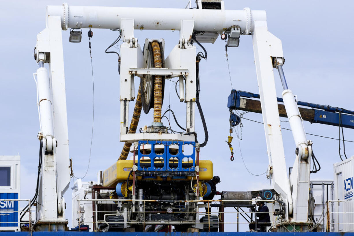 Workers on the vessel Nautilus that helped bury the subsea cables that run along the ocean floor to connect the wave energy test site to facilities on land near Newport, Ore., Friday, Aug. 23, 2024.