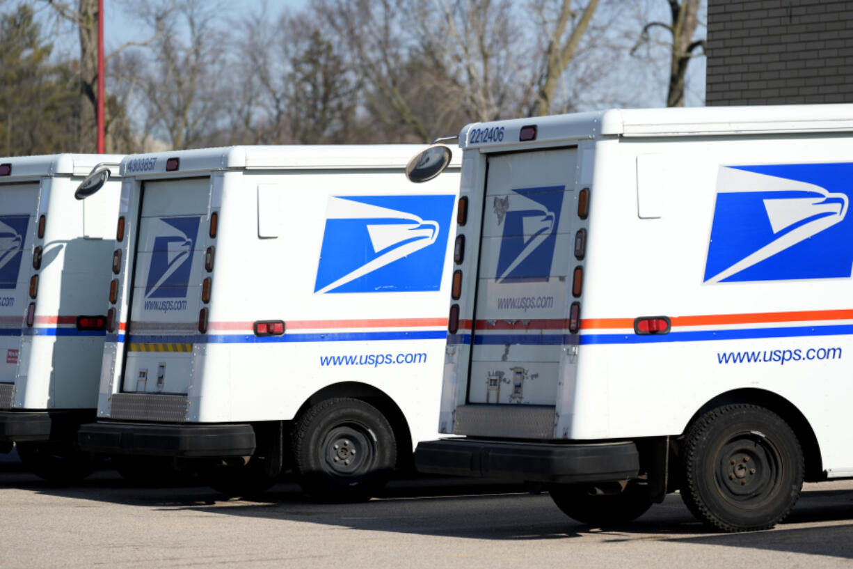 FILE - U.S. Postal Service trucks park outside a post office in Wheeling, Ill., Monday, Jan. 29, 2024. (AP Photo/Nam Y.