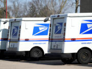 FILE - U.S. Postal Service trucks park outside a post office in Wheeling, Ill., Monday, Jan. 29, 2024. (AP Photo/Nam Y.