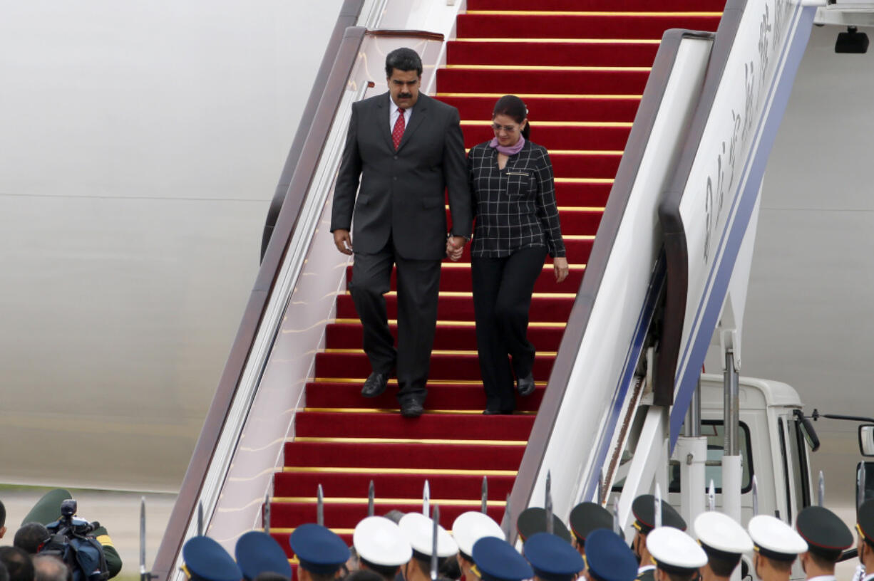 FILE - Venezuela&#039;s President Nicolas Maduro, left, and first lady Cilia Flores arrive at Beijing Capital International Airport in Beijing, China, Sept. 1, 2015.