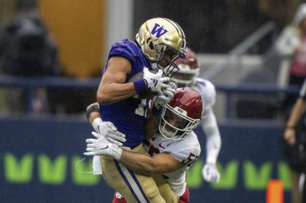 Washington wide receiver Leon Neal Jr., left, is tackleb y Washington State linebacker Kyle Thornton during the second half of an NCAA football game on Saturday, Sept. 14, 2024, in Seattle. Washington State won 24-19.