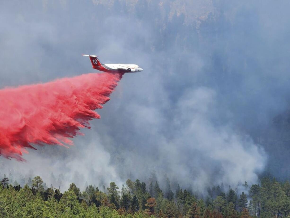 A heavy air tanker dumps fire retardant over the First Thunder Fire on Tuesday, Sept. 3, 2024 near Rapid City, S.D.