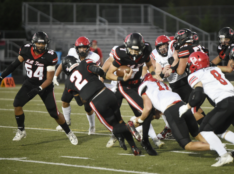 Camas quarterback Jake Davidson (7) fights for yardage against the Oregon City defense during the first half of Friday's non-league football game at Doc Harris Stadium on Sept. 28, 2024. Davidson hit five different receivers for seven touchdowns in a 48-14 win over Oregon City.