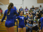 La Center's Paige Sherry (3), Bailey Espana (4), Quinn Erickson (right) celebrate a Wildcats points during a 1A Trico League volleyball match Thursday, Sept. 19, 2024. La Center won the match, 3-0.