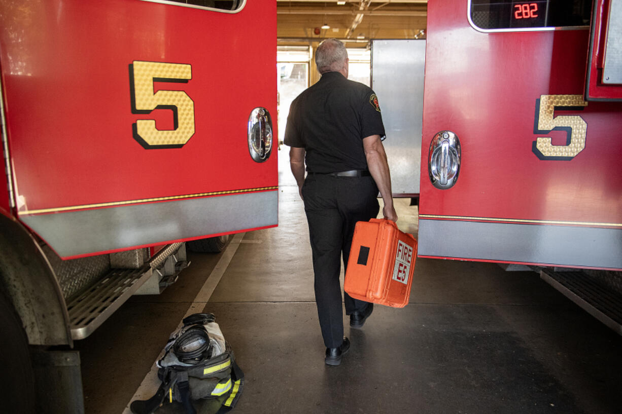 Robb Milano, Emergency Medical Services Division Chief, walks with an emergency medical kit. Proposed budget cuts would eliminate three positions in the Vancouver Fire Department and bring three captains back to line staffing.