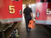 Robb Milano, Emergency Medical Services Division Chief, walks with an emergency medical kit. Proposed budget cuts would eliminate three positions in the Vancouver Fire Department and bring three captains back to line staffing.