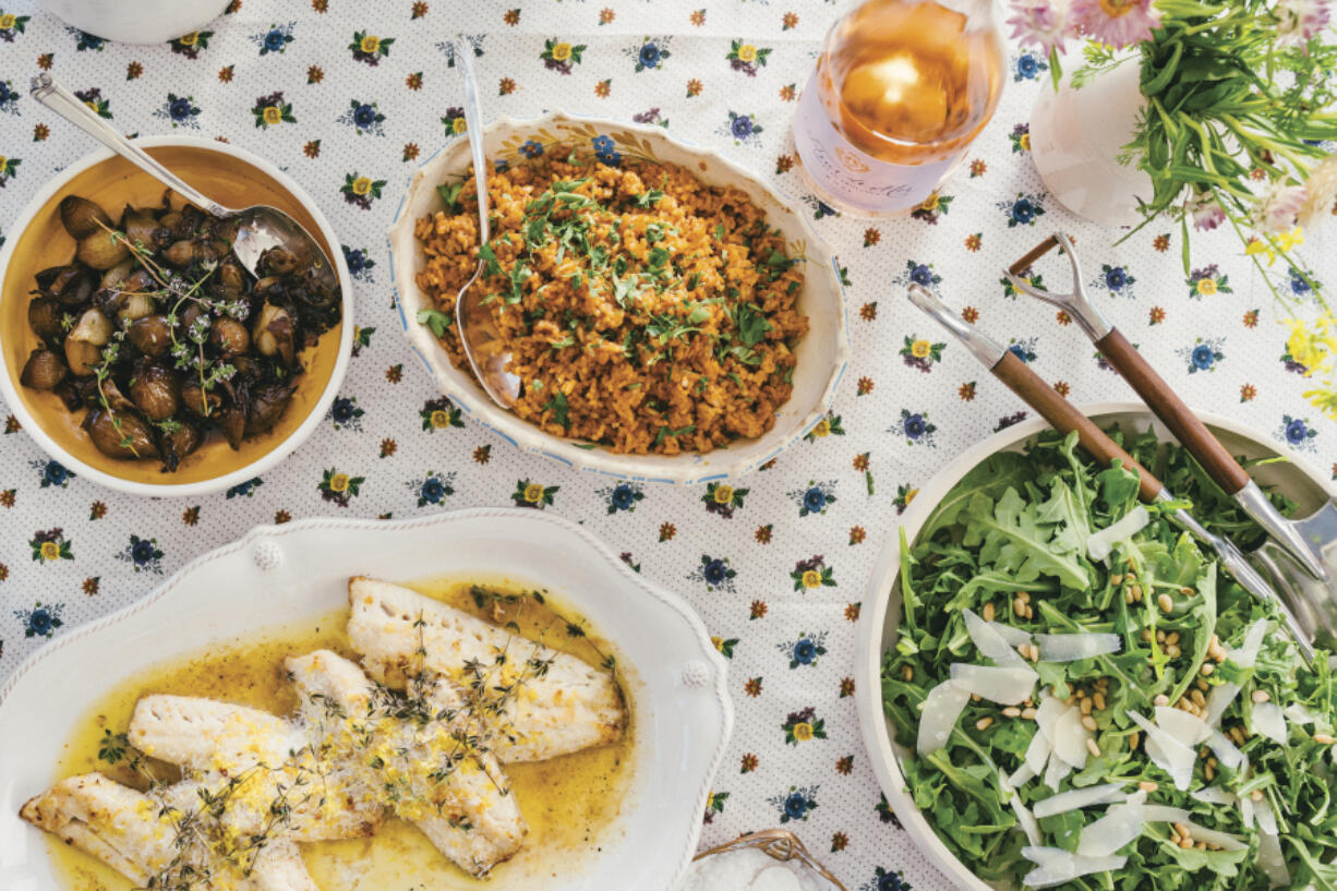 This image released by Celadon Books shows a table spread featuring a red rice dish, top center, from the cookbook &ldquo;Does This Taste Funny: Recipes Our Family Loves&rdquo; by Stephen Colbert and Evie McGee Colbert.