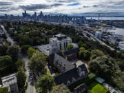 Seen from the air with downtown Seattle in the background, Saint Mark&rsquo;s Episcopal Cathedral, at center, on Sept. 23, 2024, sits next to its St. Nicholas property, in the foreground. The church wants to turn St. Nicholas into affordable housing. So far, St. Mark&rsquo;s hasn&rsquo;t been able to find a developer with the bandwidth to take on the project, a reflection of the dire need for housing in Seattle and the limited funds available to make affordable housing projects happen.