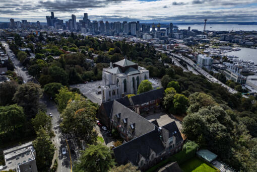 Seen from the air with downtown Seattle in the background, Saint Mark&rsquo;s Episcopal Cathedral, at center, on Sept. 23, 2024, sits next to its St. Nicholas property, in the foreground. The church wants to turn St. Nicholas into affordable housing. So far, St. Mark&rsquo;s hasn&rsquo;t been able to find a developer with the bandwidth to take on the project, a reflection of the dire need for housing in Seattle and the limited funds available to make affordable housing projects happen.