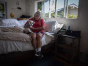 Patty Perkinson and her dog Nike are remaining at her home in Rancho Palos Verdes despite landslides that have prompted utilities to cut electrical and natural gas services in the area.