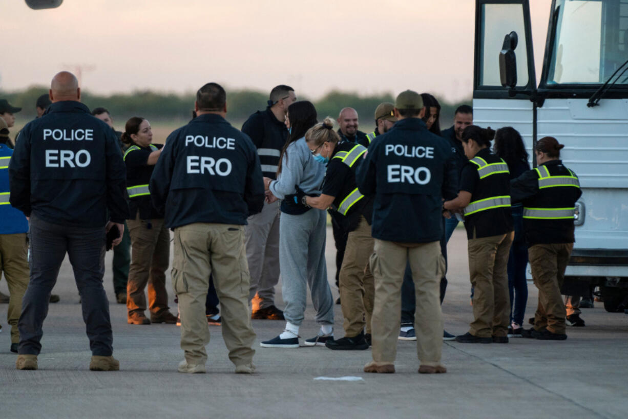 A woman in shackles is patted down before boarding the first deportation flight of undocumented Venezuelans after a U.S.-Venezuelan agreement in Harlingen, Texas, on Oct.18, 2023. (Veronica G.