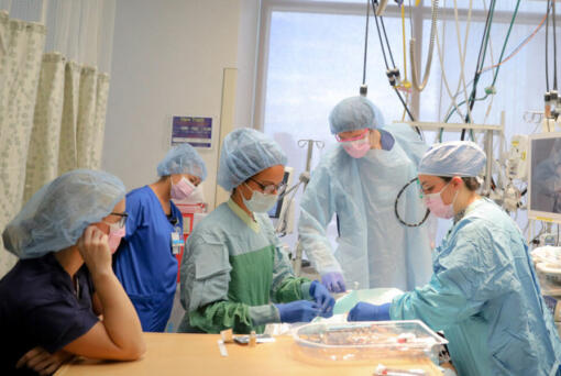 Dr. Deepika Nehra, third from left, and the trauma surgery team perform a feeding tube insertion procedure Oct. 1 in the surgical ICU at Harborview Medical Center in Seattle. Nehra and her team often work with gun shot wound patients.