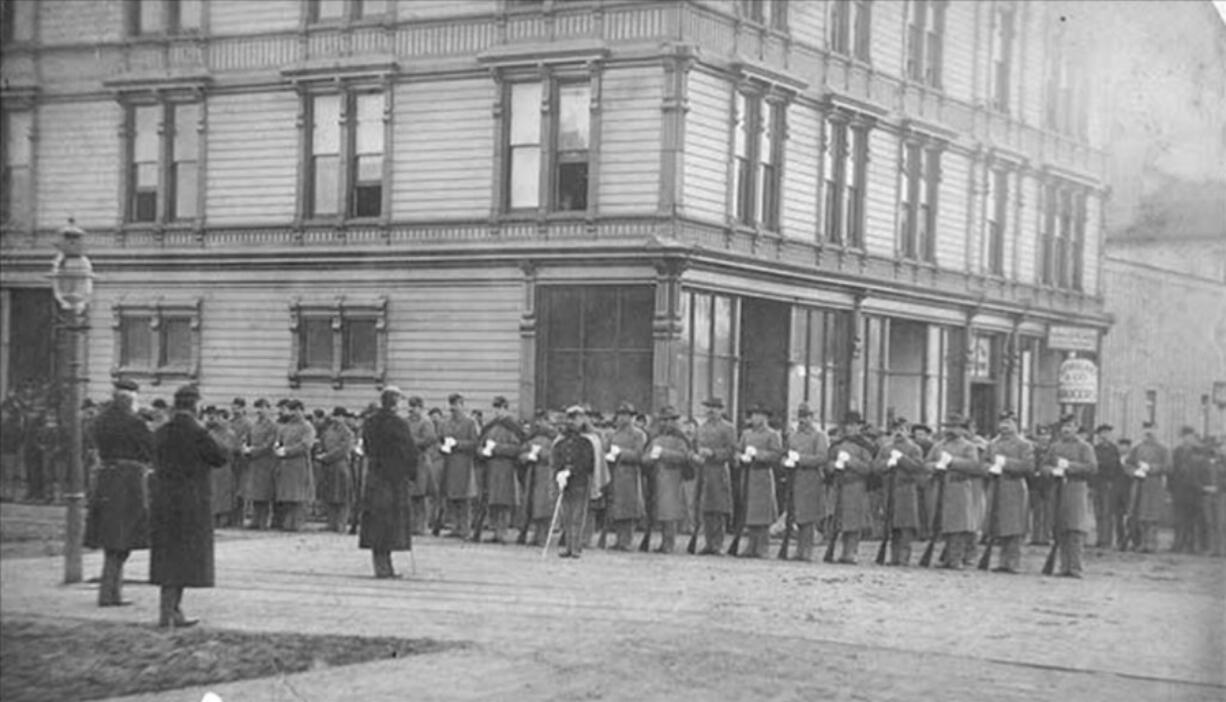 U.S. troops, possibly part of the 14th Infantry from Vancouver Barracks under command of Brig. Gen. John Gibbon, lined up in front of a downtown Seattle hotel during the anti-Chinese mob violence in February 1886.