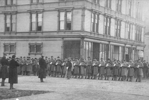 U.S. troops, possibly part of the 14th Infantry from Vancouver Barracks under command of Brig. Gen. John Gibbon, lined up in front of a downtown Seattle hotel during the anti-Chinese mob violence in February 1886.