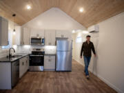 Derek Huegel, co-owner of Wolf Industries, walks through the kitchen of a one-bedroom unit in the new tiny home community, Ogden District Cottages, earlier this month.