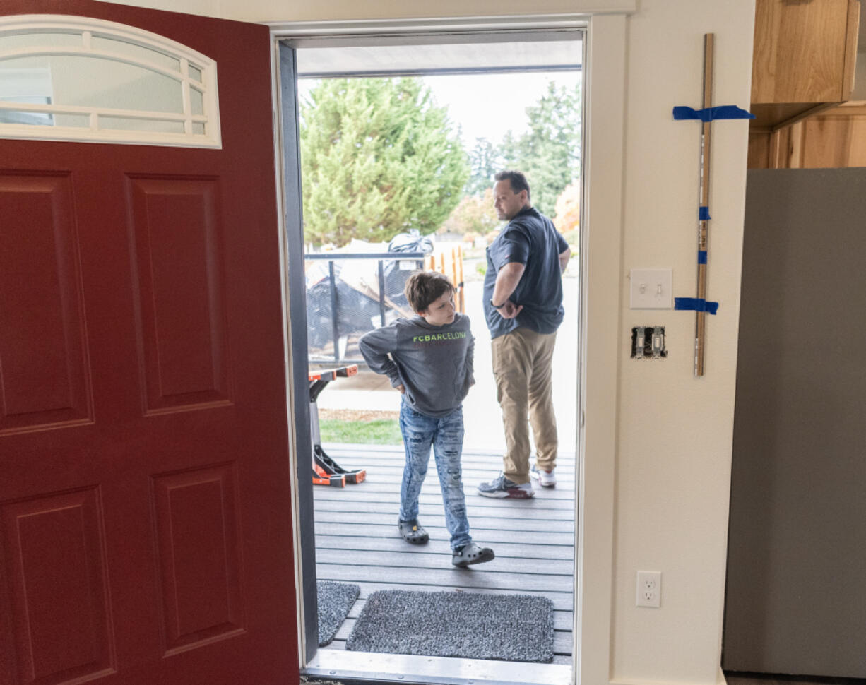 Brian Starbuck, left, ruffles the hair of his son Victor Berry, 8, at their new home in Johnson Village in Vancouver.