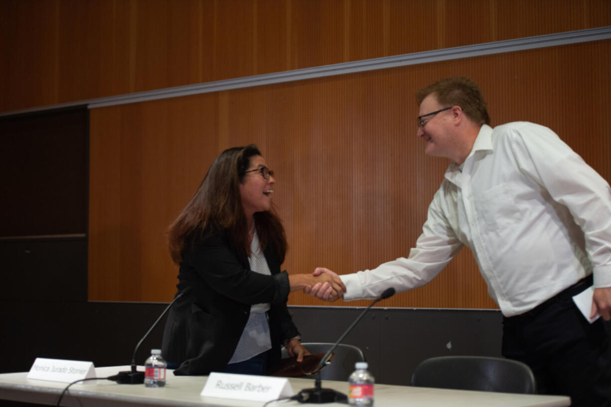 Rep. Monica Jurado Stonier, left, and challenger Russell Barber, candidates for the 49th District House, Position 2, shake hands at the beginning of their segment of a recent League of Women Voters forum.