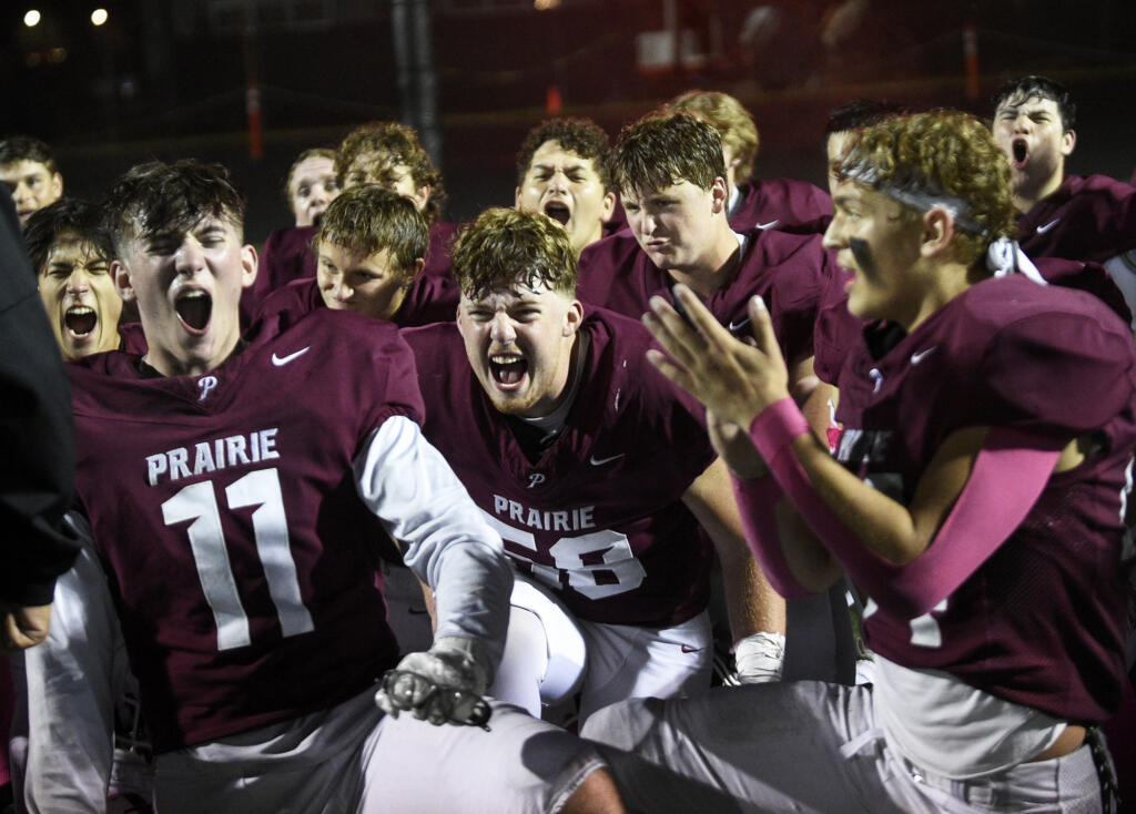 Riley Burke (11) and Judah Bullock (58) celebrate with their Prairie teammates after a 36-33 win over Mountain View in a 3A Greater St. Helens League football game at District Stadium in Battle Ground on Friday, Oct. 4, 2024.