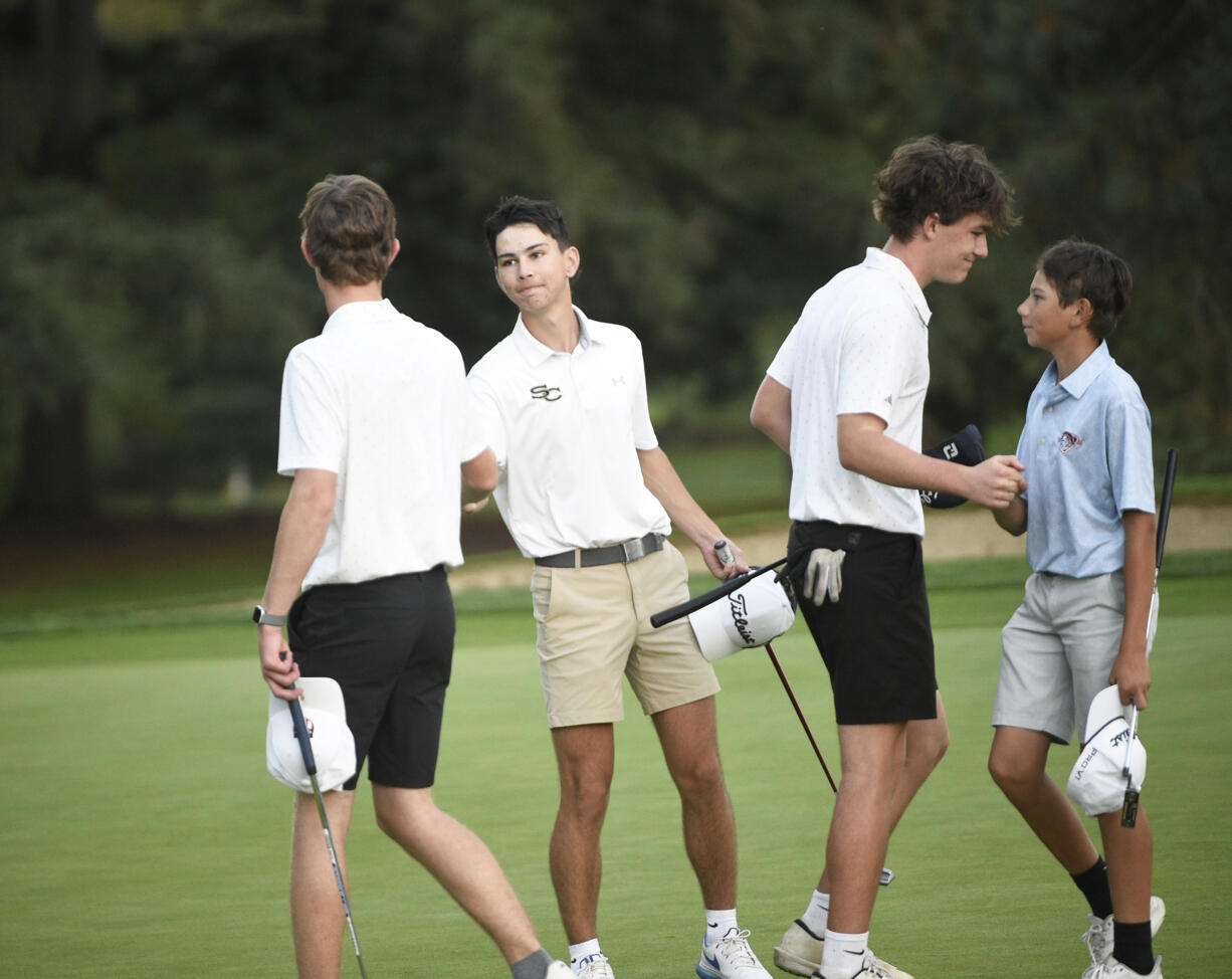 Spencer Moody of Mountain View (from left), Jacob Parker of Seton Catholic, Grady Millar of Mountain View and Christian Harlow of King's Way Christian all shake hands on the 18th green at Royal Oaks Country Club during the Clark County Cup high school golf tournament on Monday, Oct. 7, 2024.