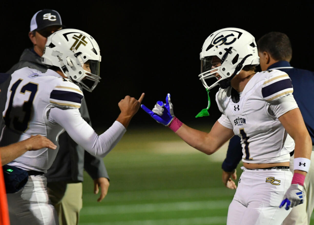 Seton Catholic junior Kolten Gesser (13) and senior Joe Callerame (1) shake hands after a touchdown during a 49-12 win over Kalama on Friday.