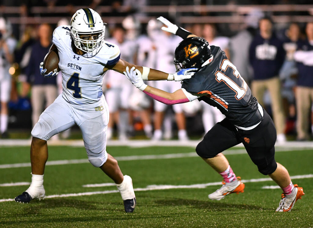 Seton Catholic senior Jacob Williams (4) stiff arms Kalama freshman Talan Thomas on Friday, Oct. 11, 2024, during the Cougars’ 49-12 win against Kalama at Kalama High School.