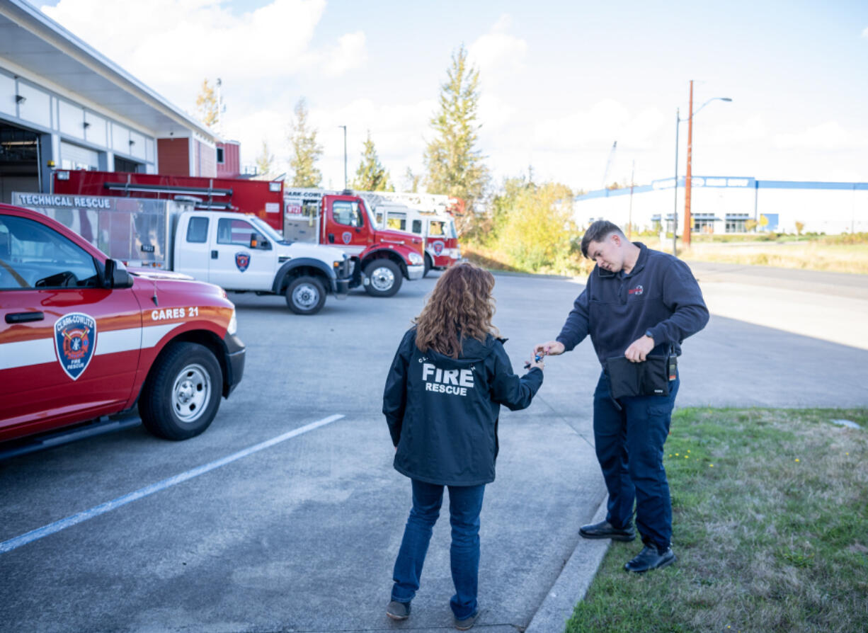 Firefighter-paramedic Connor Danielson hands car keys to mental health professional Janie Wadiak on Wednesday, while Danielson takes a call at Clark-Cowlitz Fire Rescue Station 21 in Ridgefield. The pair work as part of the Clark-Cowlitz Cares Team that can respond to community members experiencing crises.