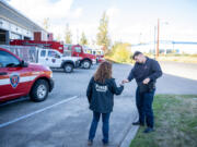 Firefighter-paramedic Connor Danielson hands car keys to mental health professional Janie Wadiak on Wednesday, while Danielson takes a call at Clark-Cowlitz Fire Rescue Station 21 in Ridgefield. The pair work as part of the Clark-Cowlitz Cares Team that can respond to community members experiencing crises.