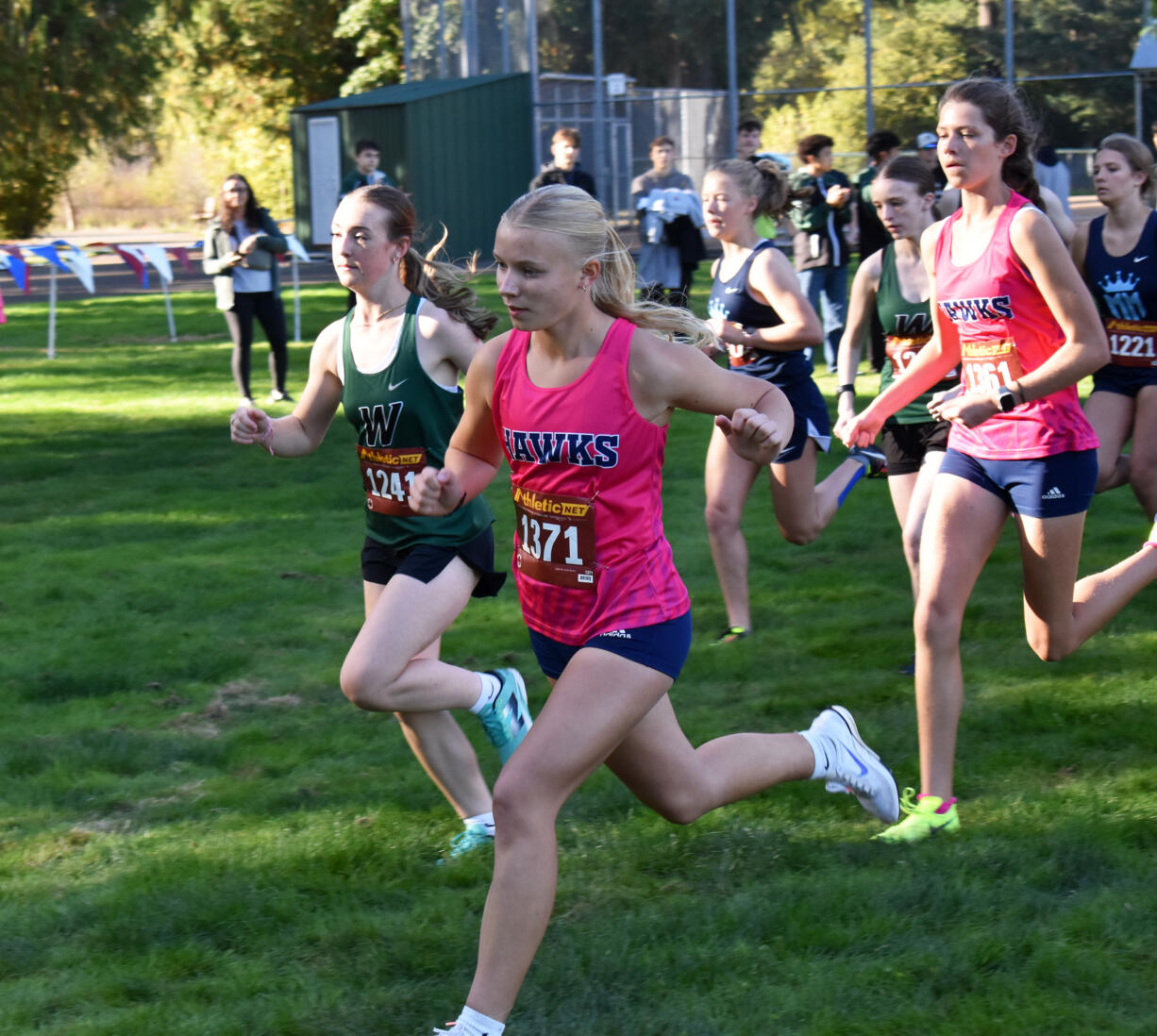 Lyla Taylor of Hockinson (1371) and Kaylynn McSmith of Woodland lead the pack at the start of the girls race at a 2A Greater St. Helens League cross country meet at Hockinson Meadows Park on Wednesday, Oct. 9, 2024.