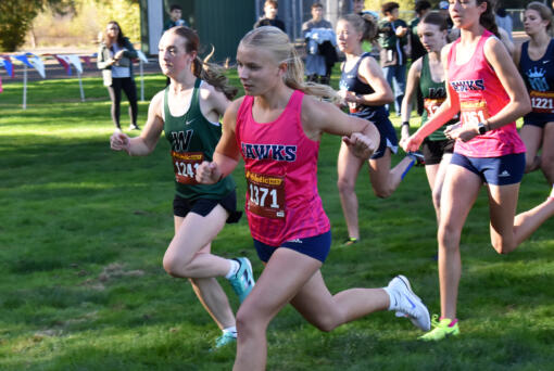 Lyla Taylor of Hockinson (1371) and Kaylynn McSmith of Woodland lead the pack at the start of the girls race at a 2A Greater St. Helens League cross country meet at Hockinson Meadows Park on Wednesday, Oct. 9, 2024. (Tim Martinez/The Columbian)