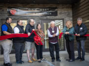 Dignitaries hold up a ribbon as Open House Ministries board of directors President Dick James, third from right, cuts Monday, during a ceremony for the new OHM West building in downtown Vancouver.