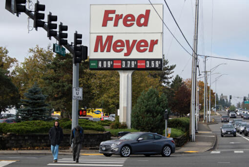 Pedestrians stroll past a sign at the Fred Meyer store in Cascade Park that reflects current gas prices last Tuesday morning. Clark County was long ago known for being one of Washington&rsquo;s more affordable counties. Now, however, it is one of the most expensive places to live in the state.