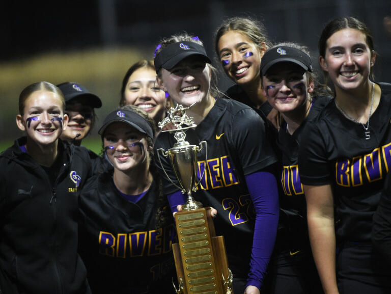 Brooklynn Vickery holds the championship trophy as she celebrates with her Columbia River teammates after the Rapids beat Kelso in the District 4 3A/2A slowpitch softball championship game at Heritage High School on Thursday, Oct. 17, 2024.