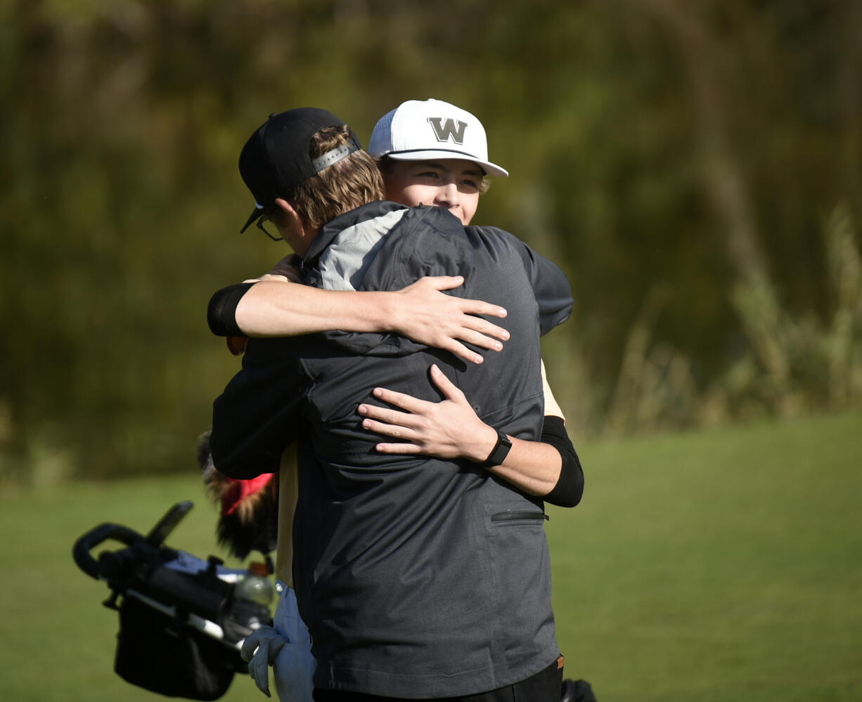 Mason Acker of Washougal hugs his father after winning the district title at Heron Lakes Golf Course during the 2A boys golf district tournament on Tuesday, Oct. 22, 2024.