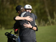 Mason Acker of Washougal hugs his father after winning the district title at Heron Lakes Golf Course during the 2A boys golf district tournament on Tuesday, Oct. 22, 2024.