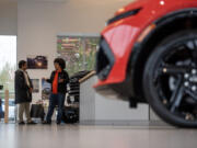 Lot attendants Ariel Day, right, and Alejandro Flores-Rosales chat at Alan Webb Chevrolet in Vancouver.