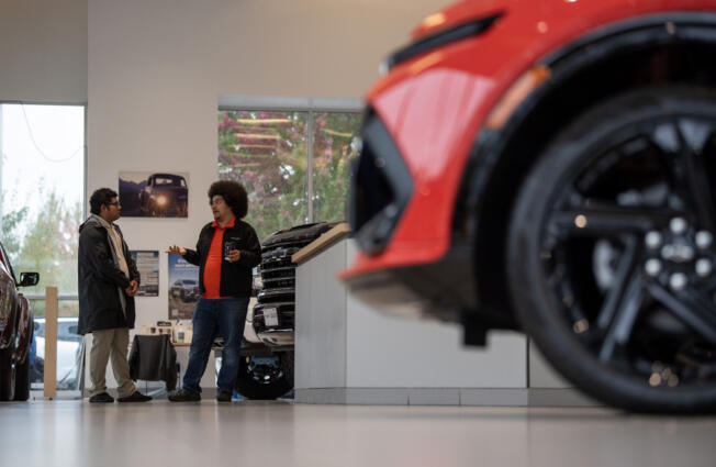 Lot attendants Ariel Day, right, and Alejandro Flores-Rosales chat at Alan Webb Chevrolet in Vancouver.