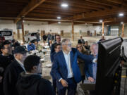 Washington Gov. Jay Inslee, center, points at a graph on a monitor Wednesday during an event celebrating clean energy development at the Cowlitz Indian Tribe Transportation Center in Longview.