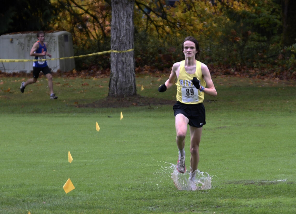 Columbia River senior Jacob McManus leads Ridgefield senior Davis Sullivan during the Class 2A boys race at the District 4 Cross Country Championships at Lewis River Golf Course on Thursday, Oct. 31, 2024.